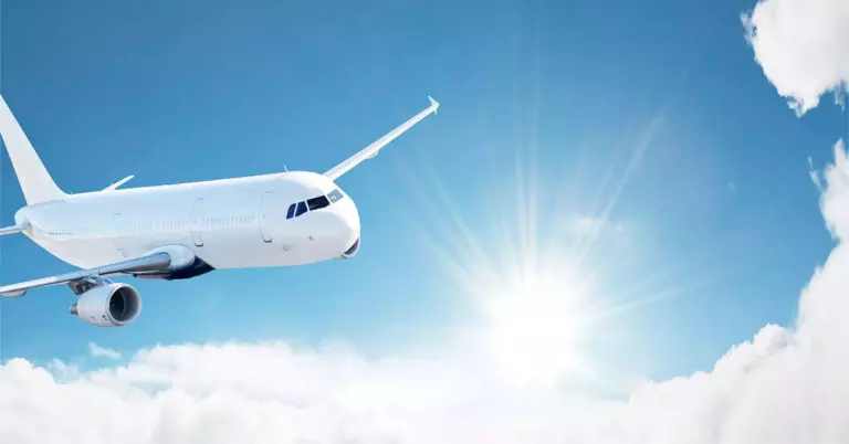 avião branco em voo, sol e nuvens
